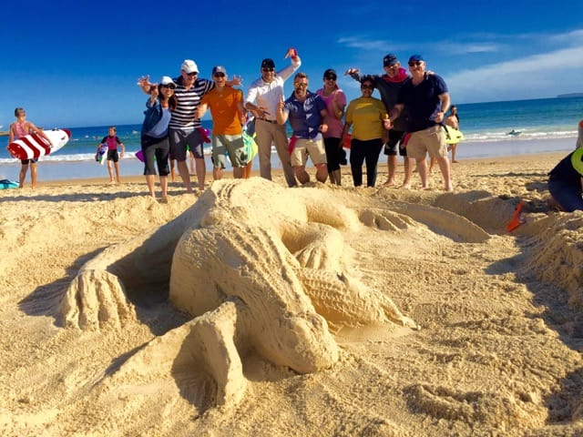 Amazing races staff beach creating and building sand sculptures on the beach with a life size crocodile