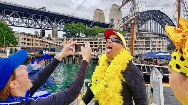 The Rocks Amazing Race fun team challenge captured by Michelle in time for staff team connection end of year celebrations by Sydney Harbour. Here the yellow team bravely completes an amazing race eating challenge by the Sydney Harbour Bridge